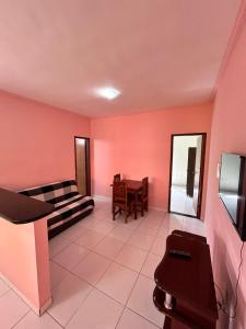 een woonkamer met roze muren en een tafel bij Apartamento no Condomínio il sole in Porto Seguro