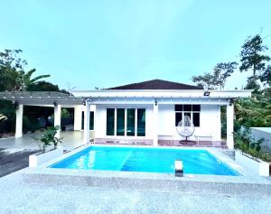 Kampong BelukarCrystal Valley Jitra的房子前面的游泳池