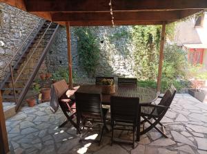 a patio with a table and chairs on a stone patio at l'Oppidum in Châteauneuf-du-Rhône