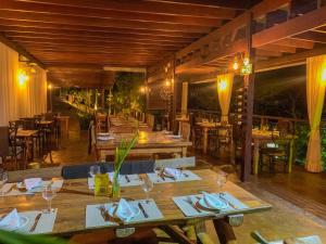 a restaurant with wooden tables and chairs in a room at Pousada Verde Villas in Brumadinho