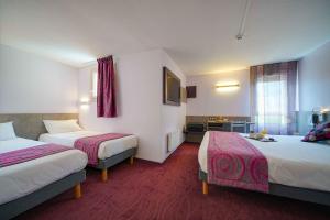 ein Hotelzimmer mit zwei Betten und einer Küche in der Unterkunft Brit Hotel Les Evens in Saint-Saturnin + 23 Fotos