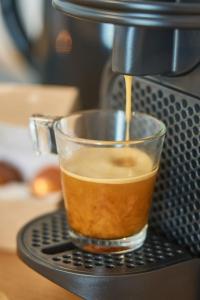 a coffee maker is making a cup of coffee at Cozy 1-Bedroom in Central Oullins Steps from the Metro in Oullins
