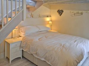Un dormitorio con una cama y una escalera. en Driftwood, en Newquay