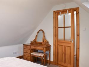 - une chambre avec une coiffeuse et un miroir dans l'établissement Sycamore Cottage - Uk45923, à Ballater 12 autres photos