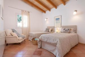 a bedroom with two beds and a chair in it at House Beach & Golf Costa de los Pinos in Costa des Pins +28 photos