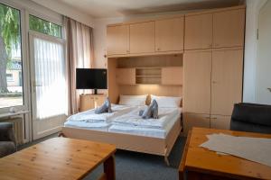 a bedroom with a large bed and a table at Haus Sonnenwinkel Bungalow 11 in Dahme +14 photos