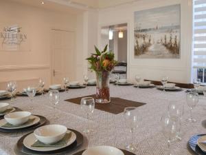 Una mesa con platos y vasos y un jarrón con flores. en Kilburn House, en Bridlington 32 fotos más