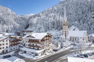 a town in the snow with a church at Hotel Stern in Längenfeld