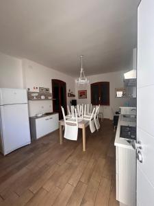 a kitchen and dining room with a table and chairs at Pearl Apartment - Baia Verde in Baia Verde