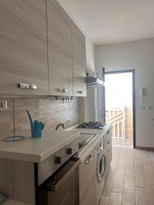 a kitchen with a sink and a stove top oven at Pearl Apartment - Baia Verde in Baia Verde +17 photos