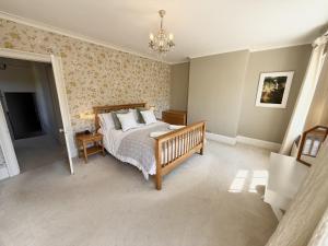 Un dormitorio con una cama y una lámpara de araña en Springfield, en Milford on Sea