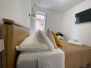 a bedroom with a bed with white pillows and a window at 2Bedroom Apartment Taormina - Murmuria Olimpia in Taormina