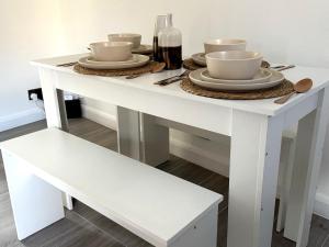 a white table with bowls and plates on it at Cosy Central Colchester Home by Castle Park in Colchester +8 photos