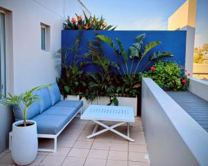 a patio with a blue bench and plants at Palm Terrace Kiama in Kiama