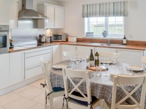 eine Küche mit einem Tisch und Weingläsern darauf in der Unterkunft Good Tides in Beadnell