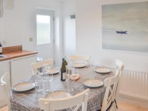 ein Esstisch mit Tellern und Weingläsern in der Unterkunft Good Tides in Beadnell