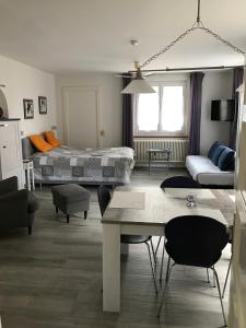 a living room with a bed and a table at Joli appartement une pièce avec place de parc in Domdidier