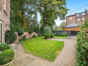 a garden with a lawn and trees and a building at The Lodge in York