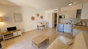 a kitchen and a living room with a table at PALMERAIE 218 in Sari Solenzara