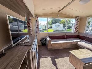 a living room with a couch and a large window at Stunning 8 Berth Caravan At Cherry Tree Holiday Park In Norfolk Ref 70711C in Great Yarmouth