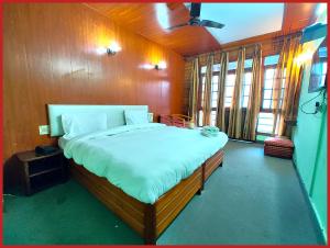 ナイニタールにあるHotel R - Radha - Continental -Mall Road Nainital - Near Naini Lake with Restaurant - Wifi - with Excellent Hospitality - A Luxury Room With Newly Decorated and Renovated Room- Book Nowの部屋の中に大きなベッドがある寝室