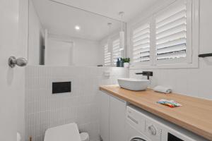 La salle de bains blanche est pourvue d'un lavabo et d'un comptoir. dans l'établissement Stylish 2-Bed Townhouse in Leafy Hyde Park, à Unley