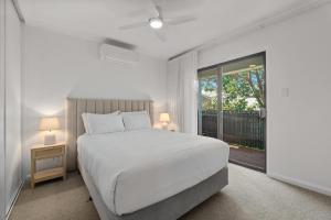 une chambre blanche avec un lit et une fenêtre dans l'établissement Stylish 2-Bed Townhouse in Leafy Hyde Park, à Unley
