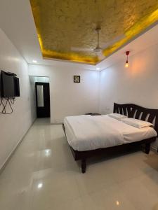 a bedroom with a bed and a flat screen tv at Vibgyor Villa in Munnar
