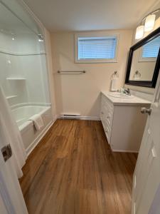 a bathroom with a tub and a sink and a mirror at Vinnecomb Apartments - Lower Floor - 2 Bedroom in St. John's
