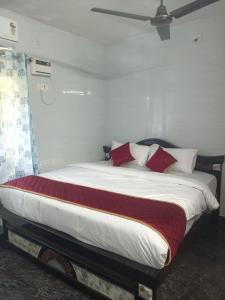 a bedroom with a large bed with red and white pillows at LAkSHMI HOMESTAY in Tirupati