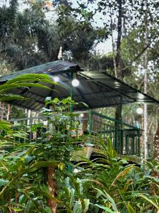 a gazebo with an umbrella in a garden at Vibgyor Villa in Munnar