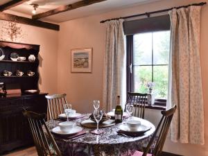 a dining room with a table and a window at Haagwood Cottage in Cretshengan