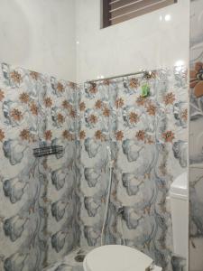 a bathroom with a shower curtain and a toilet at LAkSHMI HOMESTAY in Tirupati