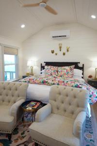 a bedroom with a bed and two chairs at Laurel Court Cottages- A Pickleball Getaway in Fredericksburg