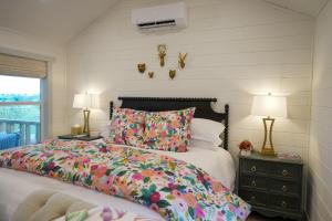 a bedroom with a bed and two lamps and a window at Laurel Court Cottages- A Pickleball Getaway in Fredericksburg