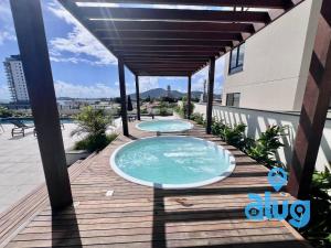 two swimming pools on a wooden deck with an awning at S801T2 Beto Carrero - Vista Mar - Games e Chopeira in Penha