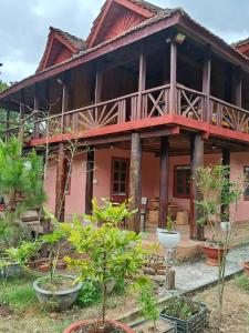 a red house with trees in front of it at Coffee Homestay A Vũ in Kon Cho Dri
