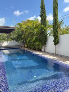 a swimming pool in front of a house with trees at Villa with a pool in Ra'anana in Ra‘ananna