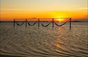 a volleyball net in the ocean at sunset at Golden Lake Residence Apart Hotel in Arraial do Cabo