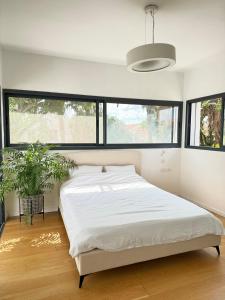 a bedroom with a bed and a large window at Villa with a pool in Ra'anana in Ra‘ananna +29 photos