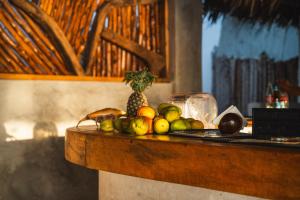 a pile of fruit on a counter with a pineapple at Dhow Beach Boutique Hotel in Nungwi