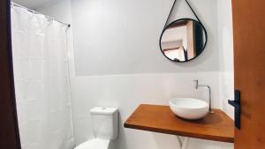 une salle de bain avec des toilettes blanches et un miroir dans l'établissement Pousada Atalaia - Arraial do Cabo, à Arraial do Cabo