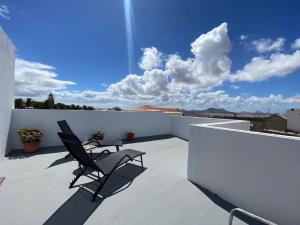 a balcony with two chairs on a white wall at Casa Veracruz in Teguise