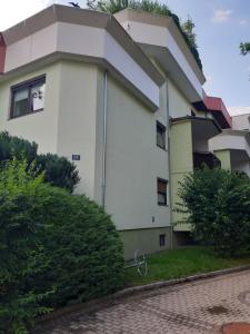 a large white building with trees in front of it at Sleep - See - Nah in Klagenfurt