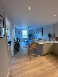 a kitchen and living room with a table and a chair at Paramount Stays - Uxbridge in Uxbridge +3 photos