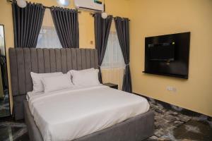 a bedroom with a bed and a flat screen tv at Jasabi s Court Apartments in Port Harcourt