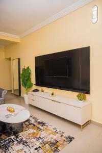 a living room with a large flat screen tv on a wall at Jasabi s Court Apartments in Port Harcourt