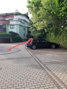 a car parked in a parking lot with a red ribbon at Sleep - See - Nah in Klagenfurt +1 photo