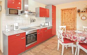 a kitchen with red cabinets and a table and a table and a tableablish at Ferienwohnung Zislow in Zislow