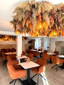 a restaurant with tables and chairs under a large chandelier at DOMAINE ST GERMER in Reilly